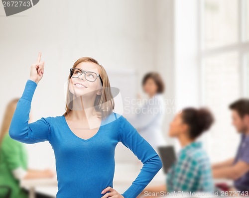 Image of smiling woman pointing her finger up