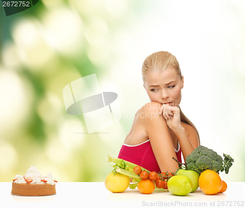 Image of doubting woman with fruits and pie
