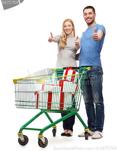 Image of smiling couple with shopping cart and gift boxes