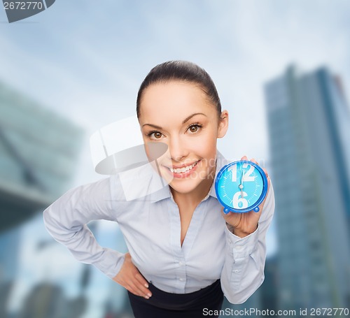 Image of smiling businesswoman with blue clock