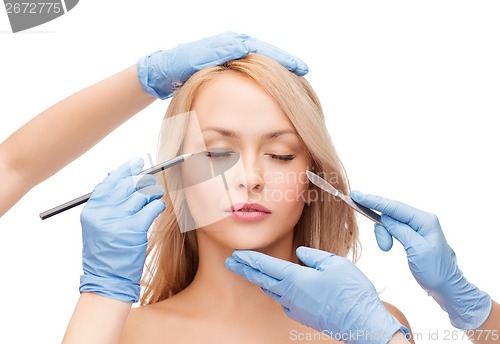 Image of woman and beautician hands with pencil and scalpel