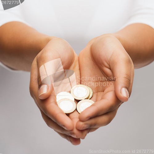 Image of womans cupped hands showing euro coins