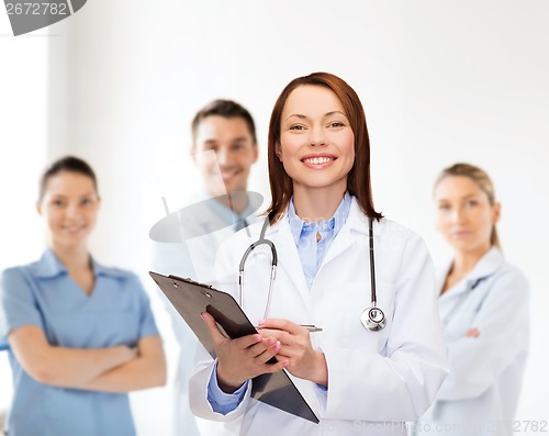Image of smiling female doctor with clipboard