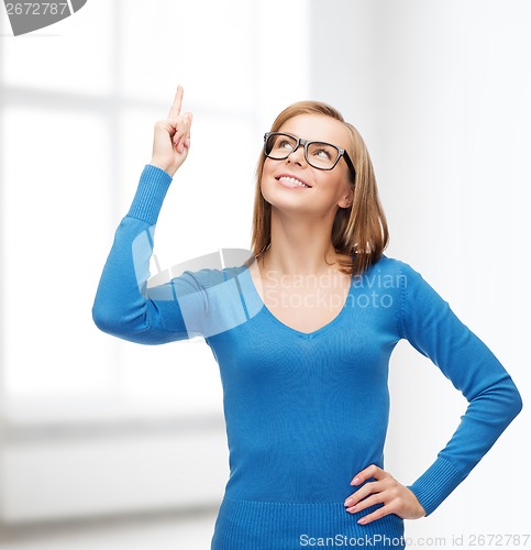 Image of smiling woman pointing her finger up