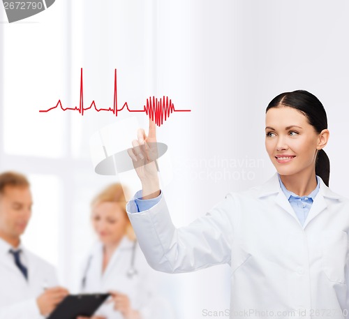 Image of smiling female doctor pointing to cardiogram