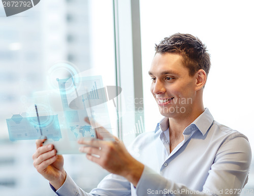 Image of smiling businessman with tablet pc in office