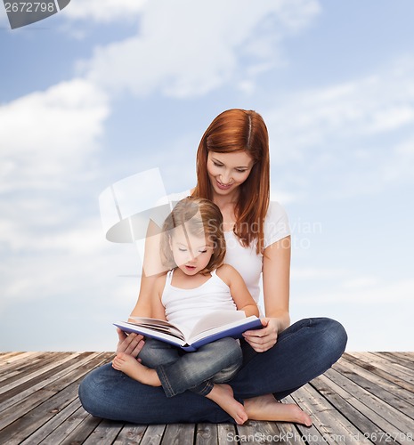 Image of happy mother with adorable little girl and book