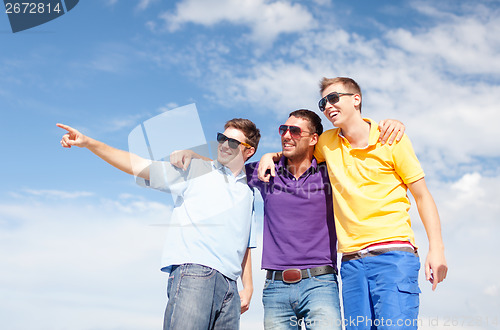 Image of group of male friends walking on the beach