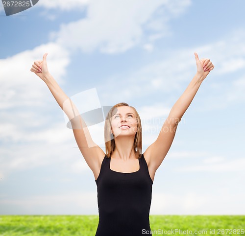 Image of woman in blank black tank top showing thumbs up