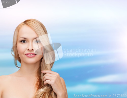 Image of beautiful woman playing with long hair