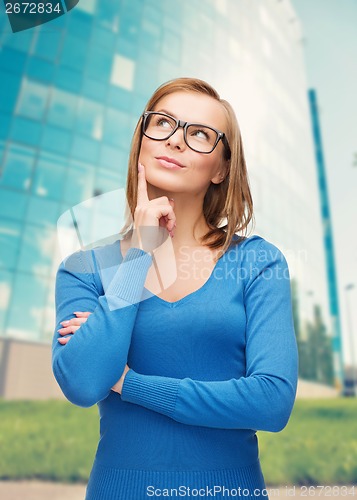 Image of happy woman in black eyeglasses dreaming