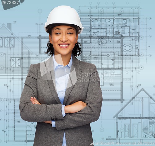 Image of businesswoman in white helmet with crossed arms