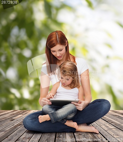 Image of happy mother with little girl and tablet pc