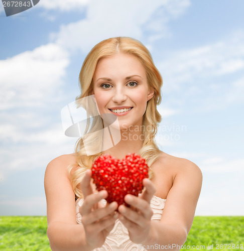 Image of smiling woman giving small red heart