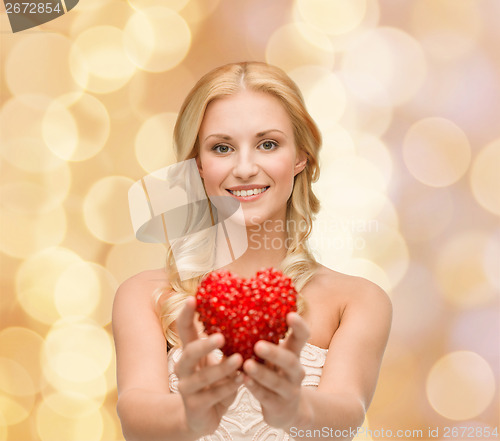 Image of smiling woman giving small red heart