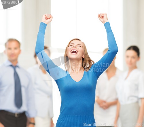 Image of laughing young woman with hands up