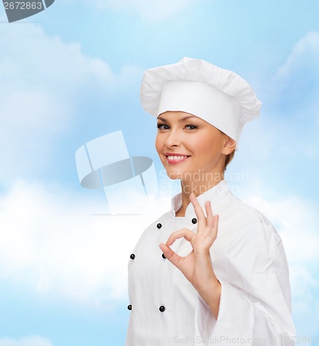 Image of smiling female chef showing ok hand sign