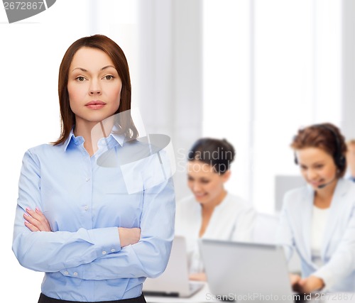 Image of smiling businesswoman with crossed arms at office