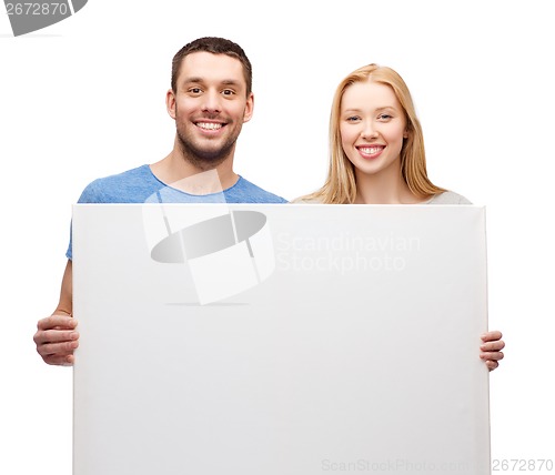 Image of smiling couple holding white blank board