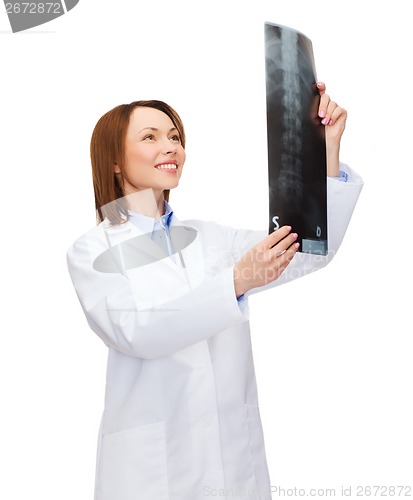 Image of smiling female doctor looking at x-ray