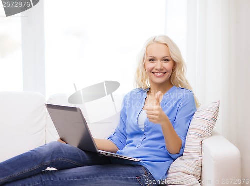 Image of smiling woman with laptop computer at home