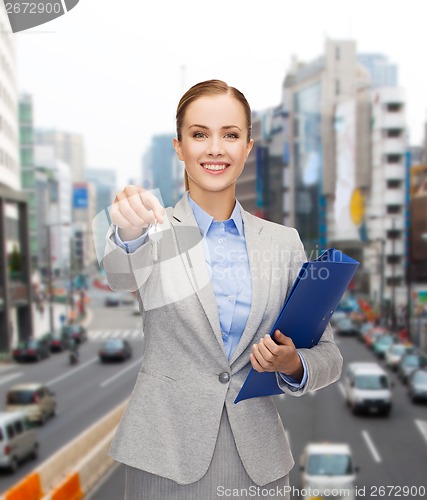 Image of smiling businesswoman with folder and keys