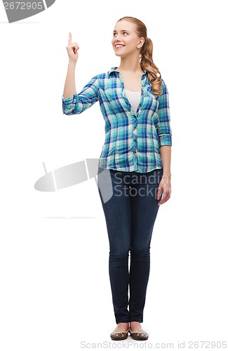 Image of smiling young woman pinting finger up