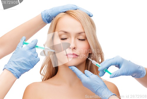 Image of woman face and beautician hands with syringes