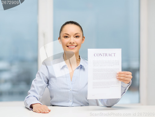 Image of happy businesswoman holding contract in office