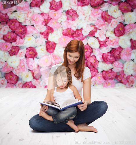 Image of happy mother with adorable little girl and book