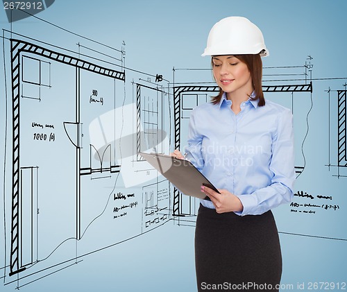 Image of smiling businesswoman in helmet with clipboard