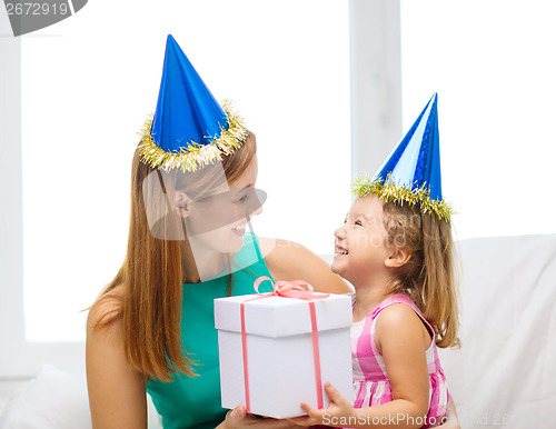 Image of mother and daughter in blue hats with favor horns