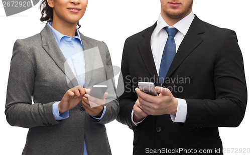 Image of businessman and businesswoman with smartphones