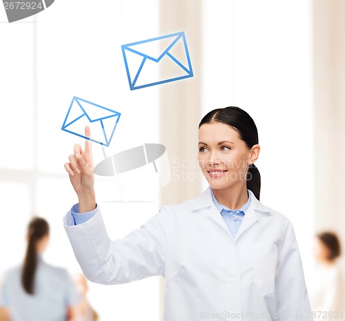 Image of smiling female doctor pointing to envelope