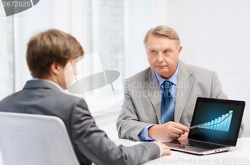 Image of older man and young man with laptop computer