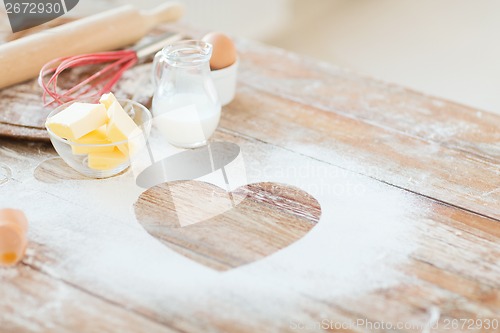 Image of close up of heart of flour on wooden table at home