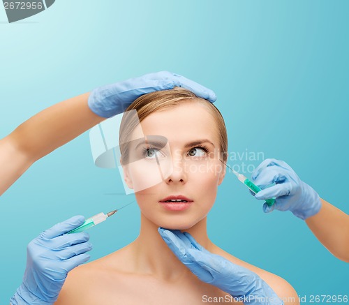 Image of woman face and beautician hands with syringe