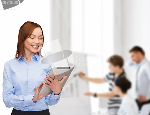 Image of smiling woman looking at tablet pc at office