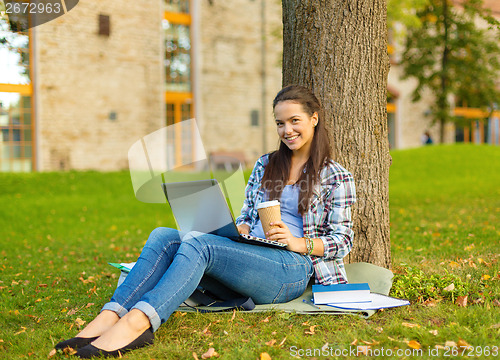 Image of teenager in eyeglasses with laptop and coffee