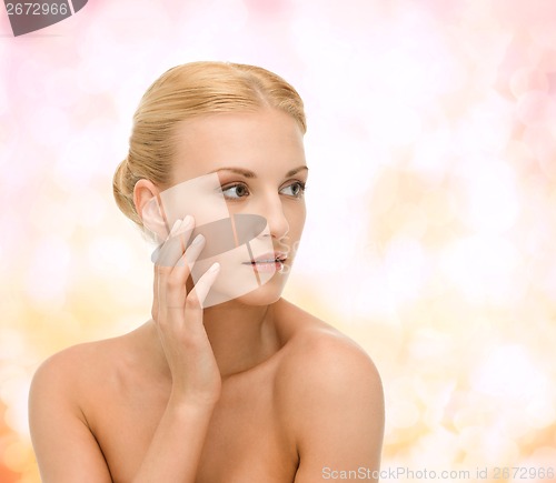 Image of beautiful woman touching her face skin