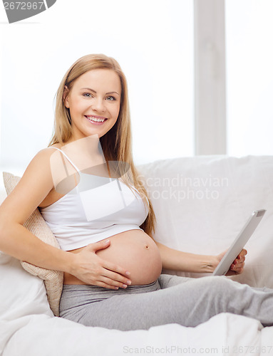 Image of smiling pregnant woman with tablet pc computer