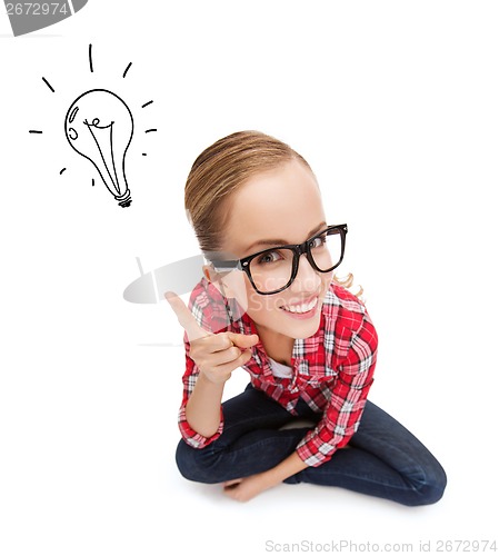 Image of smiling teenager in eyeglasses with finger up