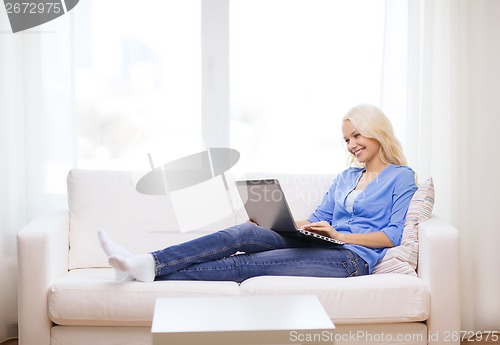 Image of smiling woman with laptop computer at home