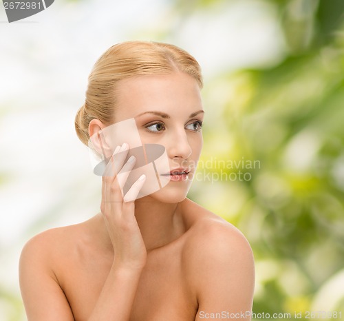 Image of beautiful woman touching her face skin