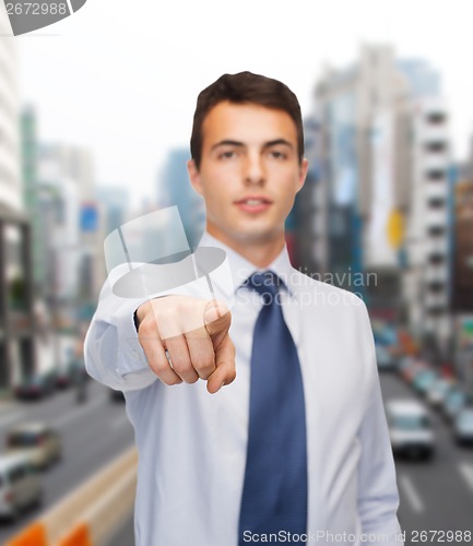 Image of friendly young buisnessman pointing finger