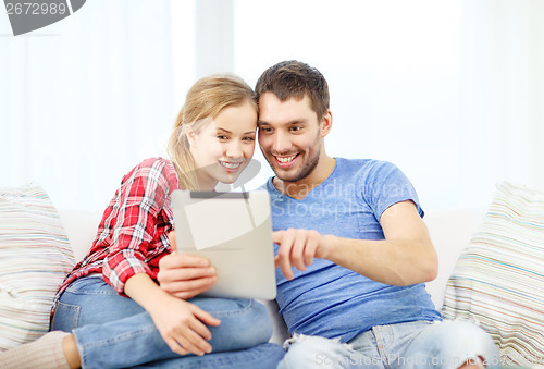 Image of smiling couple with tablet pc computer at home