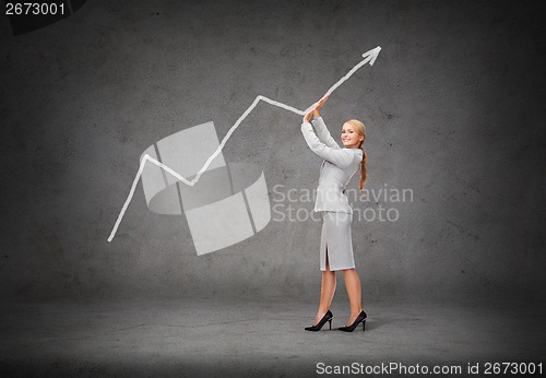 Image of young smiling businesswoman pushing up arrow