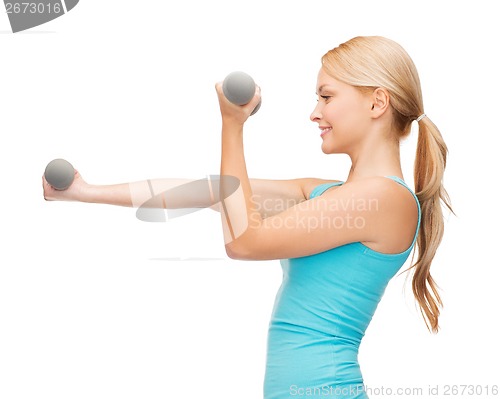 Image of young sporty woman with light dumbbells
