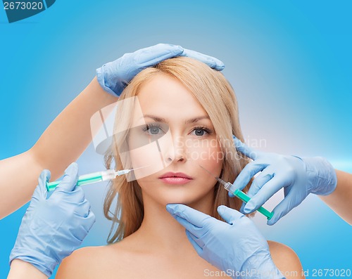 Image of woman face and beautician hands with syringes