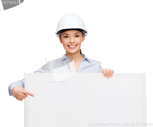 Image of businesswoman in helmet pointing finger to board